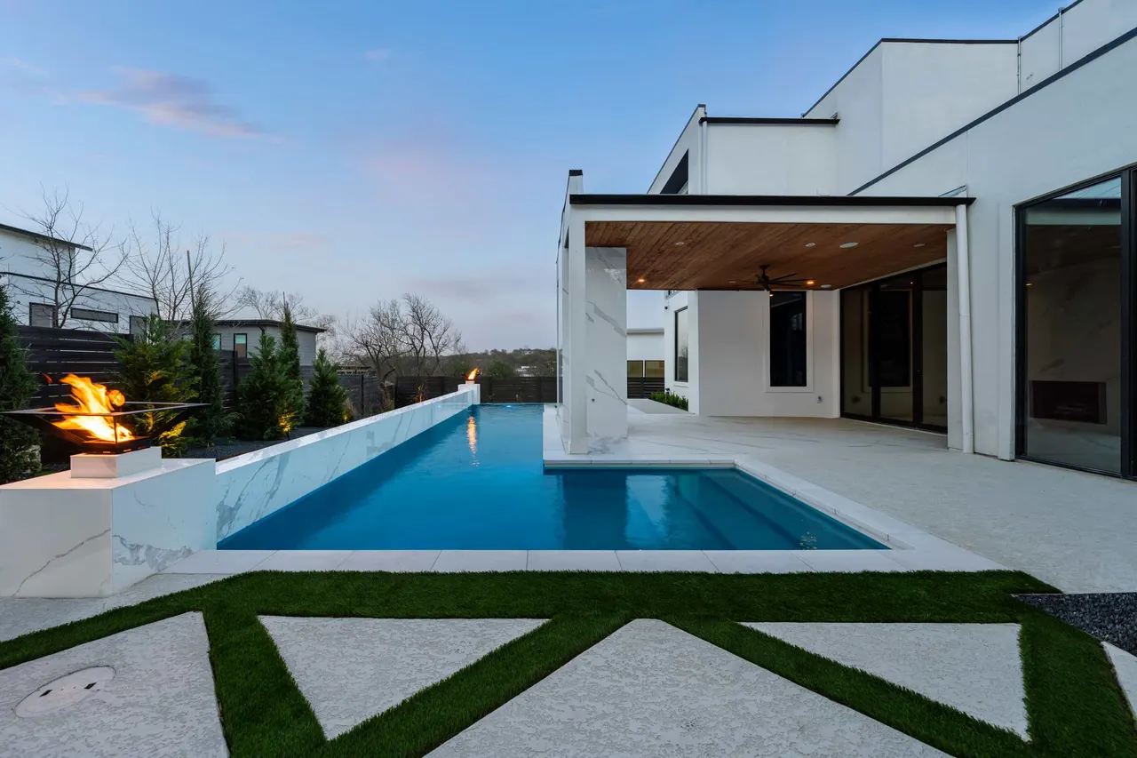 Raised pool clad in white large-format porcelain with fire bowls, Austin