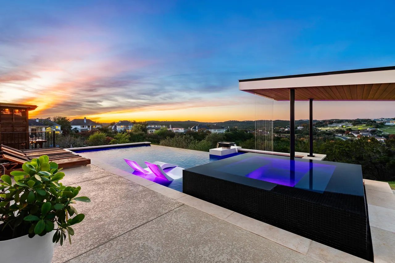 Raised vanishing-edge pool at sunset by GB IV Designs, Bee Cave